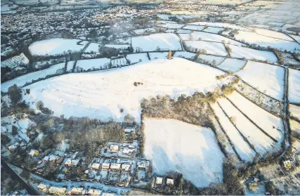  ??  ?? Above, a drone picture of Glastonbur­y covered in snow by Mario Nogales. Below left, a dog and his snowman in Newbridge, Bath, taken by Sarah Collins. Below right, a stunning shot of the Quantocks taken by Paul Silvers.