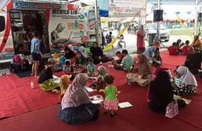  ??  ?? Children and parents alike using one of the Smart Selangor Mobile Libraries. — Selangor Public Library Corporatio­n