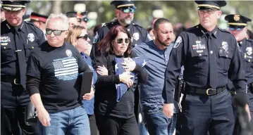  ?? SUSAN STOCKER South Florida Sun Sentinel ?? The family of Hollywood Police Officer Yandy Chirino leaves his funeral service on Monday at FLA Live Arena in Sunrise.