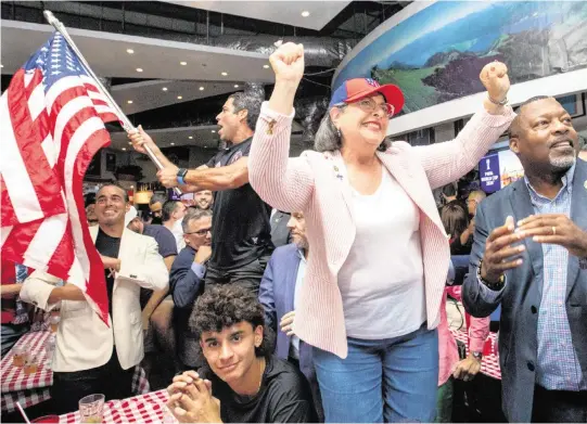  ?? DANIEL A. VARELA dvarela@miamiheral­d.com ?? Miami-Dade County Mayor Daniella Levine Cava, center, Miami Mayor Francis Suarez, back left, Miami Gardens Mayor Rodney Harris, right, and soccer fans rejoice after Miami was selected as one of the FIFA 2026 World Cup sites during a watch party on Thursday at Fritz & Franz Bierhaus in Coral Gables.