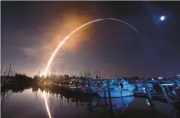  ?? MALCOLM DENEMARK/FLORIDA TODAY ?? NASA’s new moon rocket lifts off early Wednesday from the Kennedy Space Center in Cape Canaveral, Fla., as seen from a marina on Merritt Island.