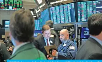  ?? — AFP ?? NEW YORK: Traders work on the floor of the New York Stock Exchange (NYSE) on Monday in New York City.