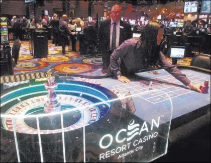  ?? Wayne Parry The Associated Press ?? A dealer pushes a stack of chips toward a gambler Sept. 28 at the Ocean Resort Casino in Atlantic City. It marked its 100th day of operation on Thursday.