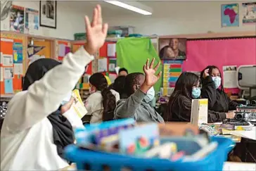  ?? SHELBY KNOWLES / CALMATTERS ?? California has released new COVID-19 isolation guidelines that allow people to return to work or school if they are asymptomat­ic. Here, students in Theresa Griffin’s sixth-grade class wore masks at Stege Elementary School in Richmond on Feb. 6, 2023.