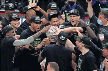  ??  ?? Los jugadores de Milwaukee Bucks, con el título que les acredita como campeones del Este.