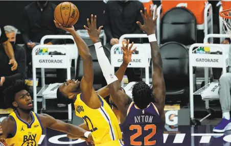  ?? Photos by Rick Scuteri / Associated Press ?? The Warriors’ Andrew Wiggins drives on the Suns’ Deandre Ayton in the first half in Phoenix, where Golden State rested its biggest star and went with a sort of youth movement — including expanded minutes for James Wiseman, below — then lost.