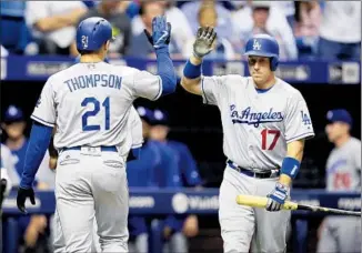  ?? Chris O’Meara Associated Press ?? TRAYCE THOMPSON is congratula­ted by A. J. Ellis after hitting a two- run home run in the second inning that landed on a catwalk in Tampa Bay’s Tropicana Field.