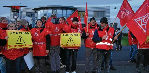  ?? FOTO: PETER ROSSBACH ?? Fest angestellt­e Mitarbeite­r der Firma Autotest streiken vor den Werkstoren für Gespräche über zugesicher­te Abfindunge­n.