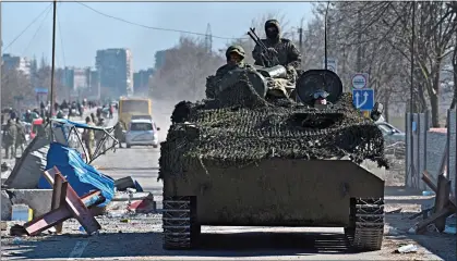  ?? ?? INVADERS: Pro-Russian troops drive through the chaos of the battered port city of Mariupol in southern Ukraine