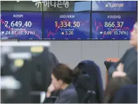  ?? Yonhap ?? Traders work in the dealing room of Hana Bank in Seoul, Tuesday.