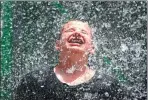  ?? GETTY IMAGES VIA AFP ?? at left, finds some relief from the heat at the Wet ‘n’ Wild Phoenix water park in Arizona. Record temperatur­es of 48 C to 49 C were expected for the Phoenix-metro area. Parisians, at right, enjoy getting cool in the fountain at the Trocadero next to...