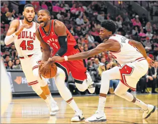  ?? AP PHOTO ?? Toronto Raptors forward C.J. Miles (centre) drives to the basket past Chicago Bulls guard Denzel Valentine (left) and guard Justin Holiday during an NBA preseason game on Oct. 13 in Chicago.