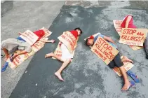  ??  ?? DEMONSTRAT­ION: Protesters stage a “die-in” to dramatize the rising number of extra judicial killings related to Philippine President Rodrigo Duterte’s “War on Drugs” in Quezon city. (AP)