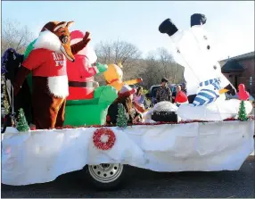  ??  ?? Rescue Fox rides atop the McDonald County 911 Dispatch Center’s entry in Southwest City’s 2015 Christmas Parade. Next to him, Frosty perfects his handstands.