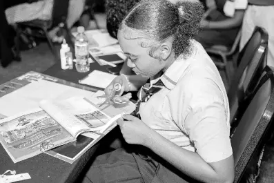  ?? ?? Shakeila Cummings, a student from Godfrey Stewart High, is seen cutting out images to include on her 2024 vision board.