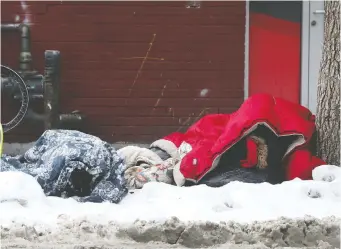  ?? TONY CALDWELL ?? Two homeless people try to stay warm on George Street on Thursday. A city homeless shelter is experienci­ng a COVID-19 outbreak.