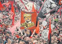  ?? PHOTO: AFP ?? Leverkusen fans celebrate on the pitch with a banner of “King Xabi” (Bayer Leverkusen’s Spanish head coach Xabi Alonso) after the German first division Bundesliga football match Bayer 04 Leverkusen v Werder Bremen in Leverkusen, western Germany, on Sunday. Bayer Leverkusen were crowned 2023-24 Bundesliga champions for the first time on Sunday.