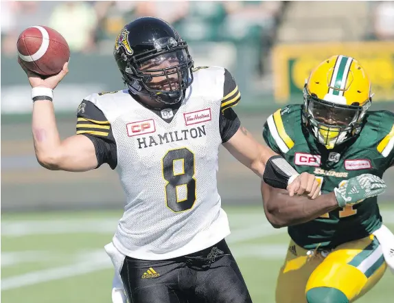  ?? — THE CANADIAN PRESS FILES ?? Hamilton Tiger-Cats quarterbac­k Jeremiah Masoli, left, throws as Edmonton Eskimos’ Odell Willis closes in during first half CFL action in Edmonton on Saturday. Masoli made 23 consecutiv­e passes to lead the Ticats to a come-from-behind win.