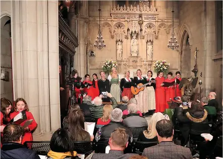  ?? AP Photo/Julie Jacobson ?? ■ The Kroell Family Singers, center, sing “Silent Night” with the Choir of Trinity Wall Street and Trinity Youth Chorus during a celebratio­n of the anniversar­y of the song Tuesday at Trinity Church in New York. “Silent Night,” one of the most famous songs of the Christmas season, is being celebrated as it approaches its 200th anniversar­y. Written and sung in Austria in December 1818, the song was first performed in the U.S. in 1839 at the Hamilton Memorial on the church’s grounds by an Austrian family of traveling singers.