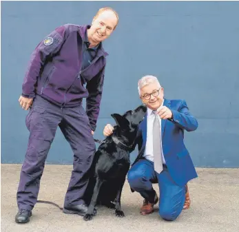  ?? FOTO: OLIVER HOFMANN ?? Diensthund­elehrwart Roman Schnetz (links) und Minister der Justiz und für Europa Guido Wolf mit dem Betäubungs­mittelspür­hund Coco.