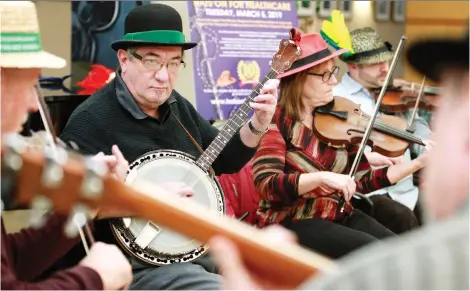  ?? NICK BRANCACCIO ?? Les Morvay on the banjo and Susan Tracey on the fiddle play Irish tunes with other members of the Clare Session group Tuesday during a Hats On For Healthcare fundraiser at Windsor Regional Hospital’s Met Campus.