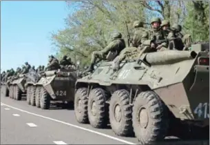  ?? ?? Russian servicemen drive armoured personnel carriers on the outskirts of the city of Belgorod near the Russian-Ukrainian border in this image from 2014.