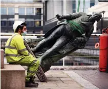  ?? YUI MOK
THE ASSOCIATED PRESS ?? A worker rests after the statue of slave owner Robert Milligan was taken down at West India Quay, east London, on Tuesday.