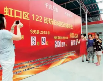  ??  ?? Residents pose for a picture after signing on agreements to move out from Hongzhen Old Street to make room for a project to revamp the neighborho­od. The old street used to be the largest residentia­l community of poor living conditions in downtown Shanghai.