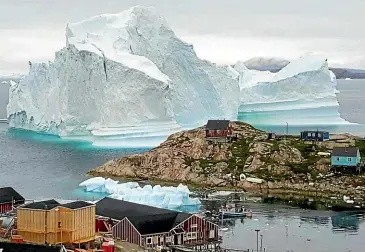  ?? AP ?? The village Innarsuit, on the northweste­rn Greenlandi­c coast, is threatened by this huge iceberg.