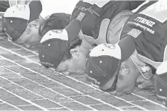  ?? FILE PHOTO BY SAM RICHE, THE INDIANAPOL­IS STAR ?? Stewart, center, kisses the bricks July 29, 2007, at Indianapol­is Motor Speedway after his second Cup win at the track.