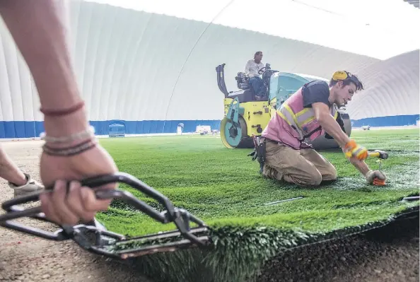  ?? SHAUGHN BUTTS ?? Crews at the Edmonton Soccer Dome are in the final stages of preparatio­n for the upcoming indoor soccer season. The dome was recently inflated, and workers are installing the turf. General manager Antony Bent says the massive facility will house activities other than soccer.