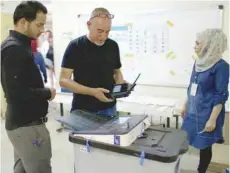  ?? — Reuters ?? Iraq’s Independen­t High Electoral Commission employee closes a ballot box at a polling station in the Sadr City district of Baghdad, Iraq, in this file photo.