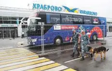  ?? Reuters ?? Russian police officers walk past a bus before the arrival of the team at the Khrabrovo Internatio­nal Airport.