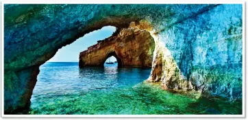  ?? ?? HOLIDAY BLUES: Navagio Beach, top, with its famous shipwreck on the shingle. Left: The hidden blue-walled caves tucked away around the coast of Zakynthos. Top left: A bedroom inside
Villa Meli