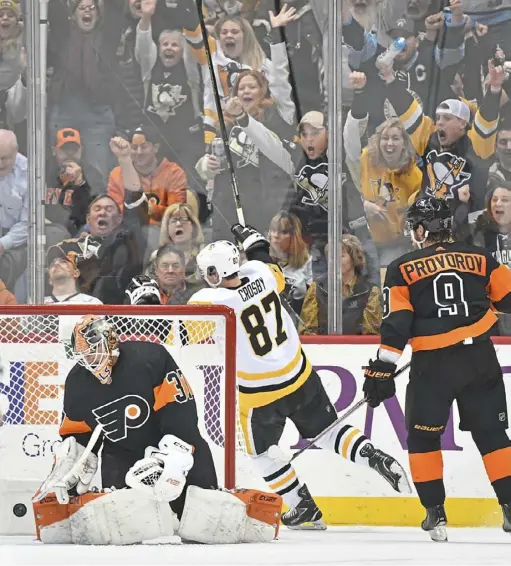  ?? Peter Diana/Post-Gazette ?? Sidney Crosby celebrates after scoring the winning goal in overtime against Flyers goaltender Brian Elliott Friday at PPG Paints Arena.