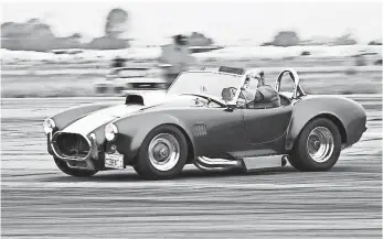  ?? COURTESY OF DEAN HORNBACHER ?? Dean Hornbacher, president of the Replica Car Club, takes the wheel of his replica Shelby Cobra, which he spent years building. Original Cobras fetch millions, but kits start at $20,000.