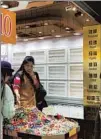  ??  ?? Tourists browse accessorie­s at a store on Nanjing Road E. — Michelle Qiao