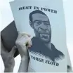  ??  ?? A DEMONSTRAT­OR holds a sign with an image of George Floyd during a Wednesday protest at the Minneapoli­s Police Department’s 3rd Precinct station to demand justice in the death of George Floyd. | AP