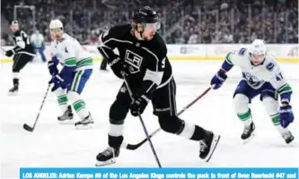  ??  ?? LOS ANGELES: Adrian Kempe #9 of the Los Angeles Kings controls the puck in front of Sven Baertschi #47 and Michael Del Zotto #4 of the Vancouver Canucks during the first period at Staples Center. — AFP