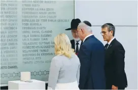  ?? (Embassy of Israel/Reuters) ?? PRIME MINISTER Benjamin Netanyahu, his wife, Sara, and Agustin Zbar (right), president of the Argentine Israel Mutual Associatio­n Jewish Community Center, stand in front of a wall with names of the victims of the 1994 AIMA bombing in Buenos Aires on...