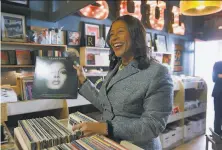  ?? Paul Chinn / The Chronicle 2018 ?? Mayor London Breed looks through records during a visit to Rooky Ricardo’s. The store has reopened with limited hours.