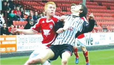  ??  ?? Battling for the ball is Robbie, who was a tenacious defender throughout his time at Ross County as a profession­al player in Scotland.