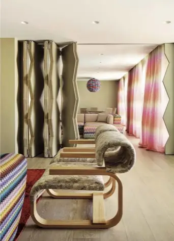  ??  ?? Un mondo disegnato. SOPRA: Rosita Missoni, che ha firmato il progetto della nuova suite dell’hotel Byblos di Saint-Tropez. A DESTRA: i due salotti della suite con la parete di separazion­e mobile, dal caratteris­tico disegno a zigzag. In primo piano il...