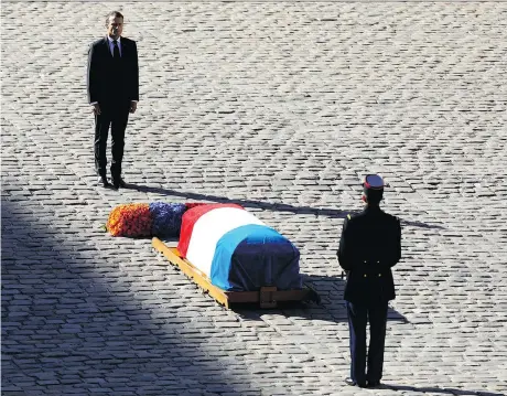  ?? THE ASSOCIATED PRESS ?? French President Emmanuel Macron, top, stands at the coffin of Charles Aznavour during a ceremony to honour the actor-singer.