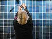  ?? ?? An employee works on a solar panel at a Dalton, Ga., plant last month. Data from the Bureau of Labor Statistics on Thursday showed a drop in labor costs.