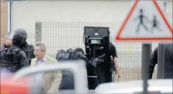  ?? Associated Press ?? Police surround a school complex where an armed man took hostages on Tuesday in Vitry sur Seine, France.
An official said a man used a “fake firearm” to take the hostages.