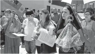  ?? AP-Yonhap ?? Araceli Huizar, second from right, from San Jose, Calif., holds a Virgin of Juquila, Oaxaca, statue as she joins Mexican Americans and Latino immigrants praying outside the Our Lady Queen of Angels Church in Los Angeles, Calif., Aug. 11, to remember those who lost their lives or were wounded in mass shootings in the states of California, Texas and Ohio.