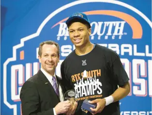  ?? BEN MCKEOWN/AP ?? Big South Conference Commission­er Kyle B. Kallander, shown presenting an MVP award to UNC Asheville’s Dwayne Sutton, describes the latest round of conference realignmen­t as “depressing.” Kallander was the final commission­er of the late Southwest Conference.