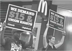  ?? JOE RAEDLE/GETTY IMAGES ?? Cecelia O’Brien, right, joins other workers to protest outside a McDonald’s in Florida. The state will raise its minimum wage, effective Tuesday, from $8.25 per hour to $8.46 per hour.