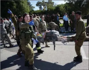  ?? The Associated Press ?? WAR TIME PREPARATIO­NS: American servicemen and Israeli soldiers participat­e in a joint drill simulating a rocket attack on March 1 at a base in Hatzor, central Israel. Israel is making contingenc­y plans to evacuate up to a quarter million people from...